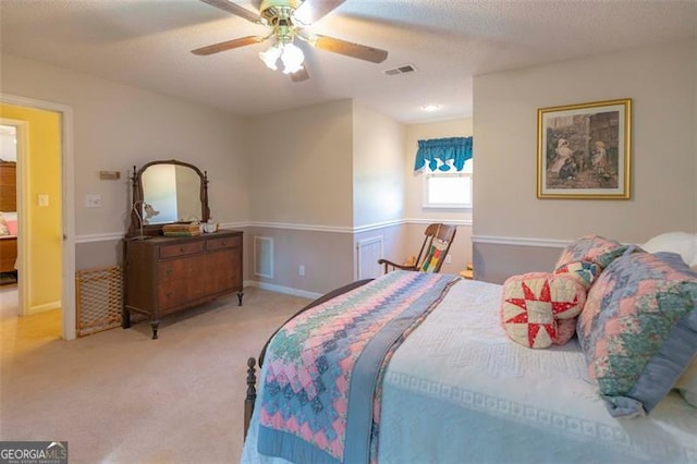 carpeted bedroom featuring a textured ceiling and ceiling fan