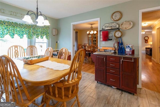 dining room featuring light wood-type flooring and a notable chandelier