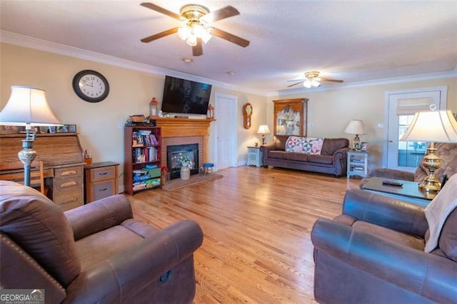 living room featuring light hardwood / wood-style flooring, ceiling fan, and crown molding