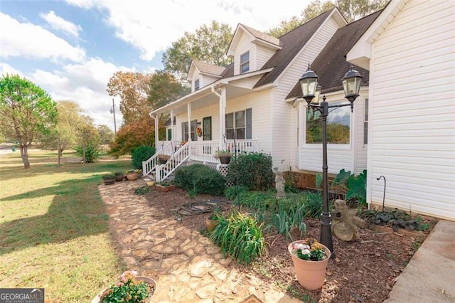 view of side of property featuring a yard and covered porch