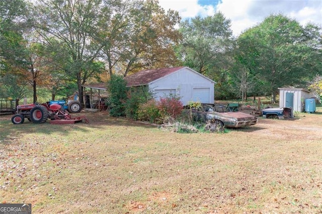 view of yard featuring a garage and a storage unit