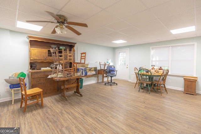 office space with hardwood / wood-style floors, ceiling fan, and a drop ceiling