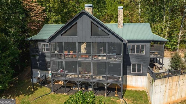 rear view of house featuring a sunroom and a balcony