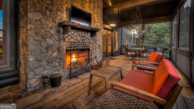 sunroom featuring an outdoor stone fireplace and beam ceiling