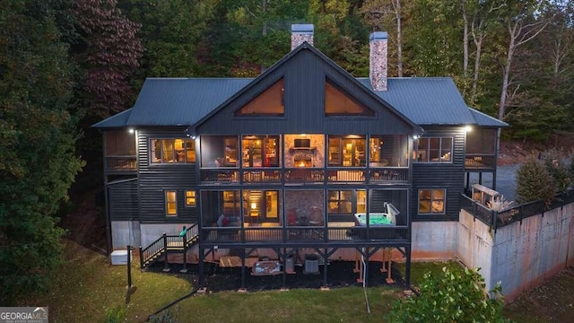 back of property with a balcony and a lawn