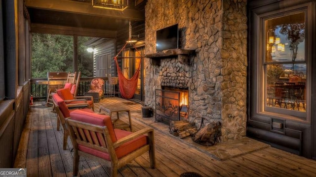 wooden deck with an outdoor stone fireplace