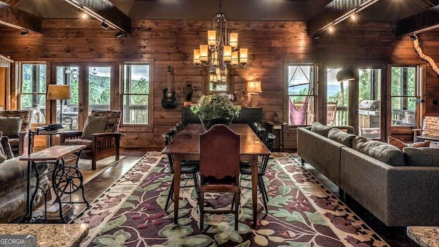 dining area featuring wood walls, beamed ceiling, and plenty of natural light