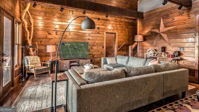 interior space with dark wood-type flooring, lofted ceiling, and wooden walls