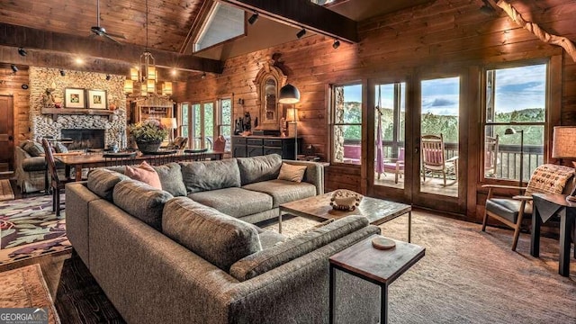 living room featuring vaulted ceiling with beams, wood ceiling, a stone fireplace, hardwood / wood-style flooring, and wood walls