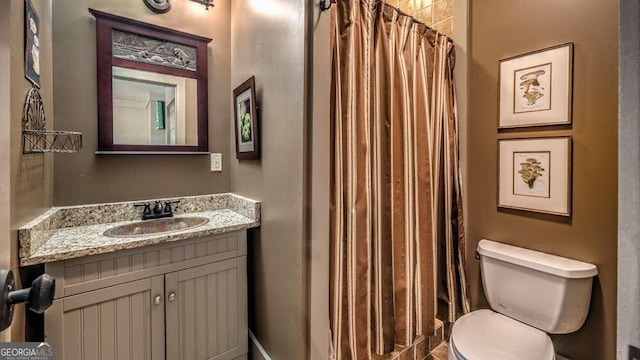 bathroom with toilet, walk in shower, and vanity