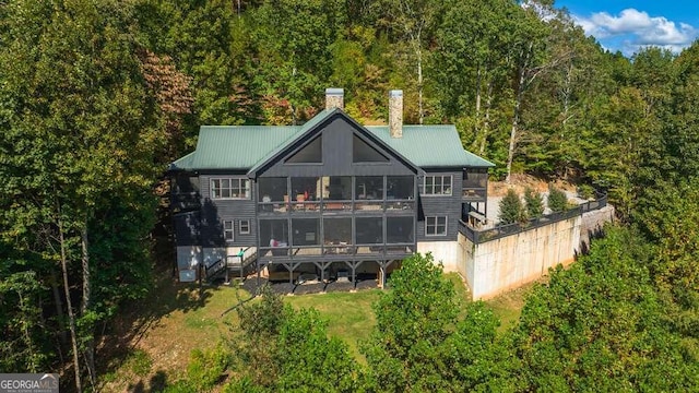 back of house with a yard, a deck, and a sunroom