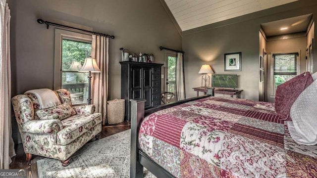 bedroom with vaulted ceiling and hardwood / wood-style floors