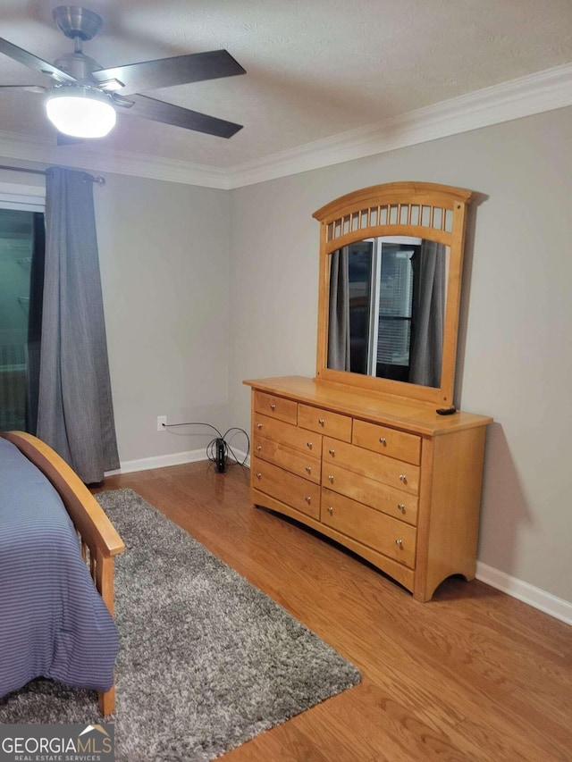 bedroom with ornamental molding, hardwood / wood-style floors, and ceiling fan