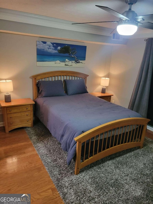 bedroom featuring crown molding, hardwood / wood-style floors, and ceiling fan