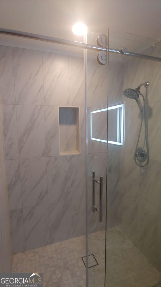 bathroom featuring a shower with door