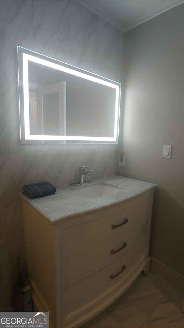 bathroom featuring vanity, plenty of natural light, and tile walls