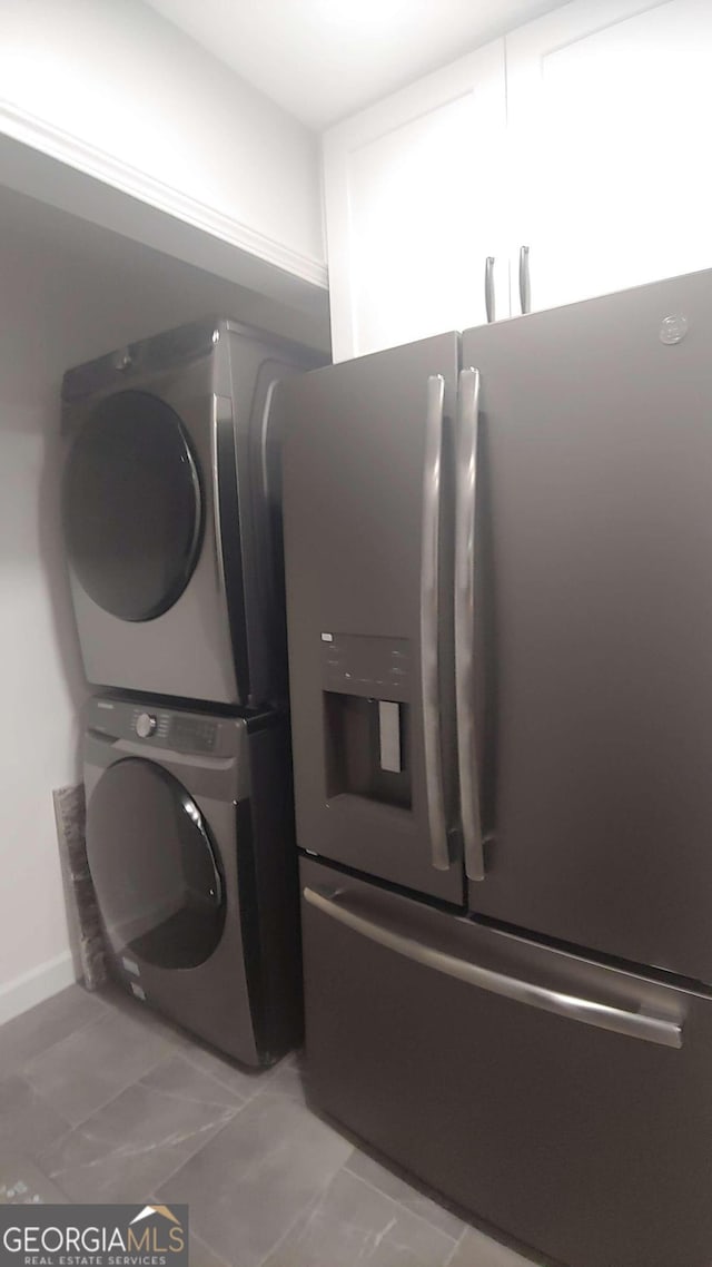 clothes washing area featuring stacked washer and clothes dryer