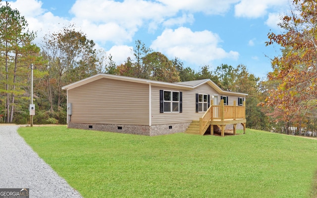 manufactured / mobile home with a front yard and a wooden deck