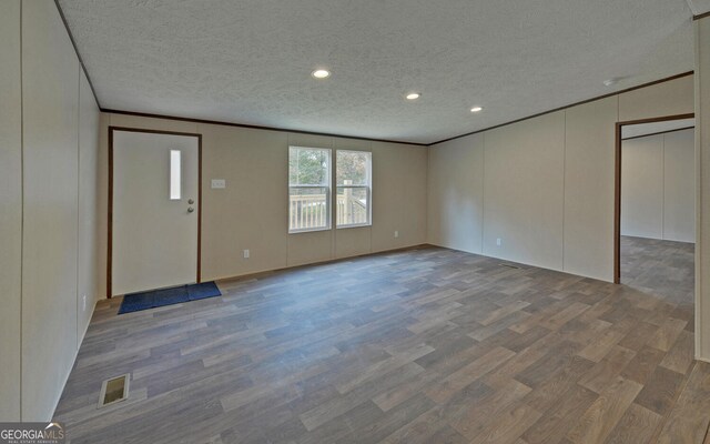 interior space featuring ornamental molding, hardwood / wood-style floors, and a textured ceiling