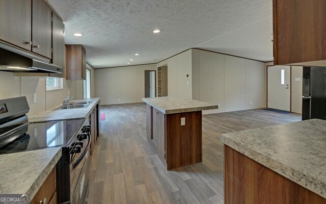 kitchen with black refrigerator, hardwood / wood-style floors, electric range, and a kitchen island