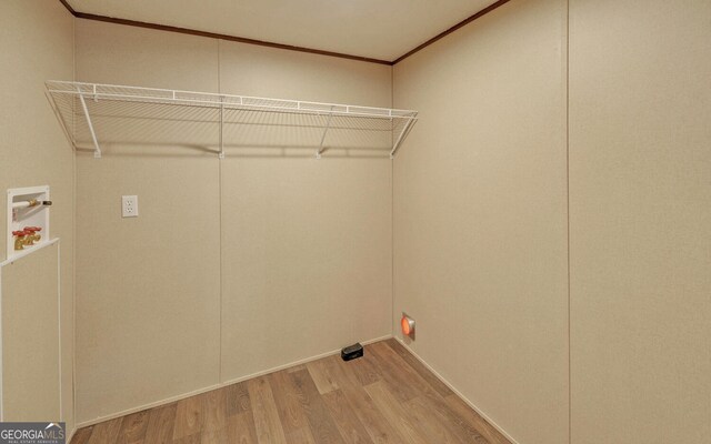 laundry room with ornamental molding, hardwood / wood-style floors, and washer hookup