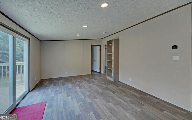 unfurnished room featuring crown molding, a textured ceiling, and hardwood / wood-style floors