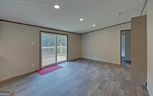 empty room with crown molding, wood-type flooring, and a textured ceiling