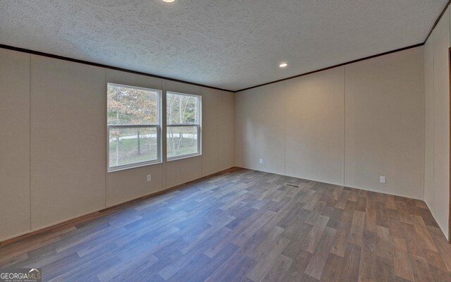 empty room with hardwood / wood-style floors and a textured ceiling