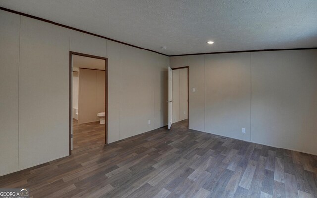 spare room featuring ornamental molding, a textured ceiling, and hardwood / wood-style flooring