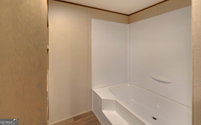 bathroom with hardwood / wood-style flooring and ornamental molding