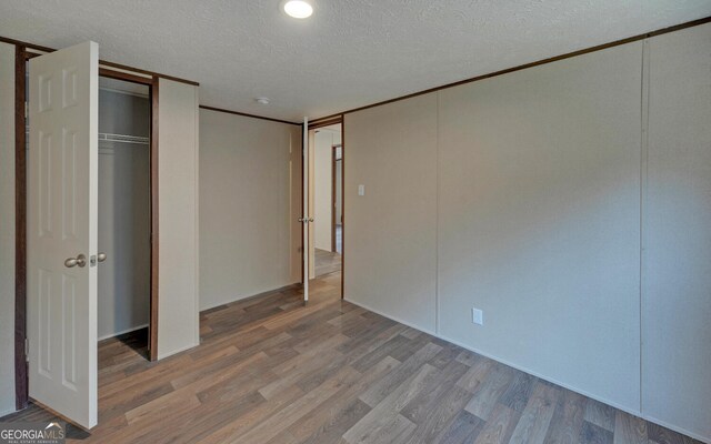 unfurnished bedroom with hardwood / wood-style floors and a textured ceiling