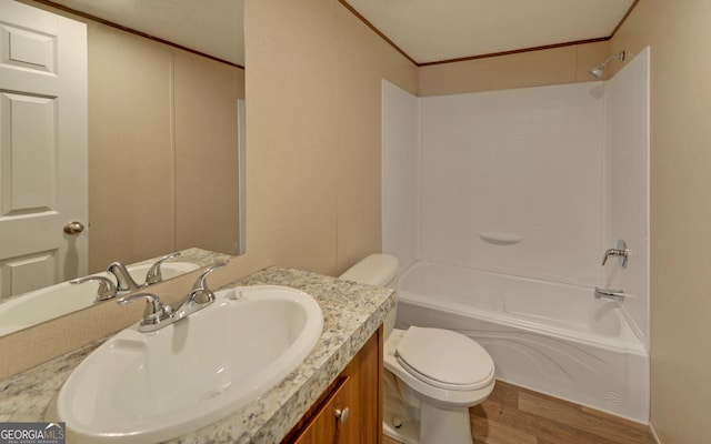 full bathroom featuring hardwood / wood-style flooring, toilet, ornamental molding, vanity, and shower / bath combination