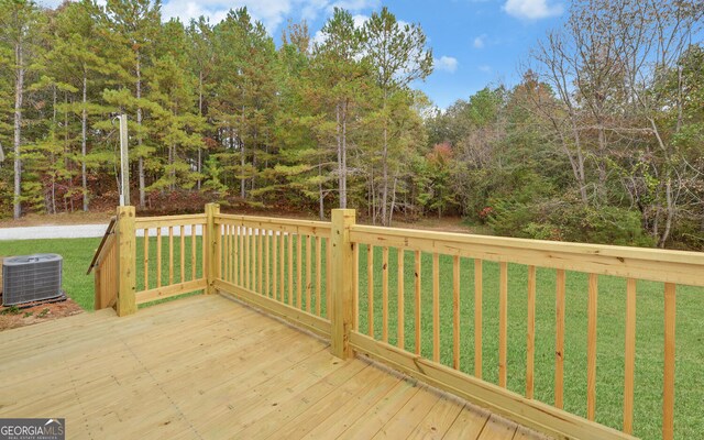 wooden deck featuring central AC and a lawn