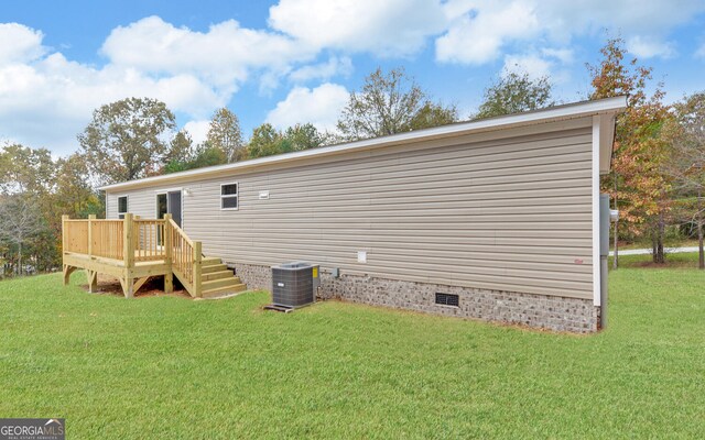 back of property featuring a wooden deck, a lawn, and central AC unit