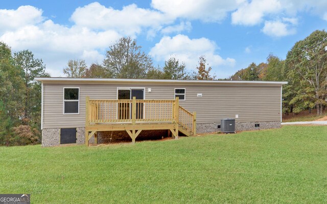 back of house featuring central air condition unit, a wooden deck, and a lawn