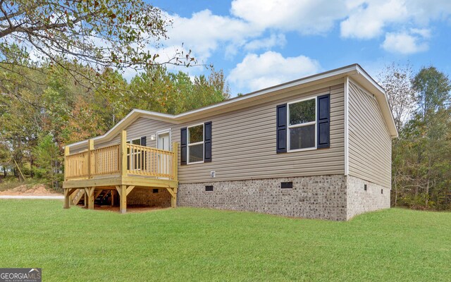 back of property featuring a deck and a lawn