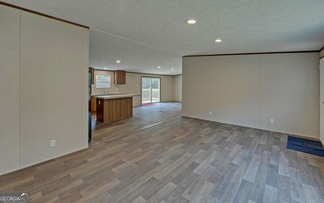 unfurnished living room with light hardwood / wood-style floors, a textured ceiling, and ornamental molding