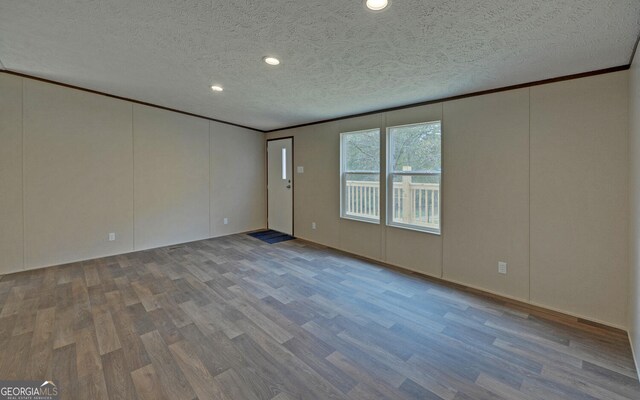 unfurnished room featuring hardwood / wood-style flooring, a textured ceiling, and ornamental molding