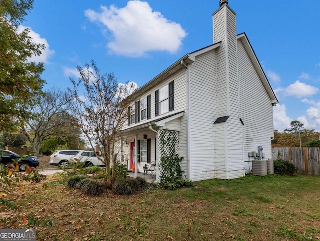 view of side of home featuring a yard and central AC