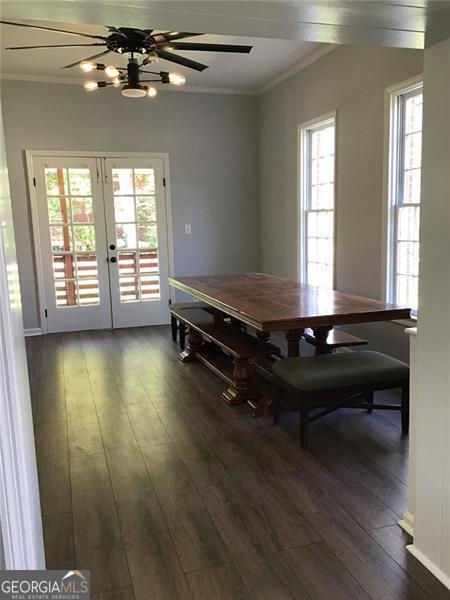 dining room featuring crown molding, dark wood-type flooring, french doors, and ceiling fan