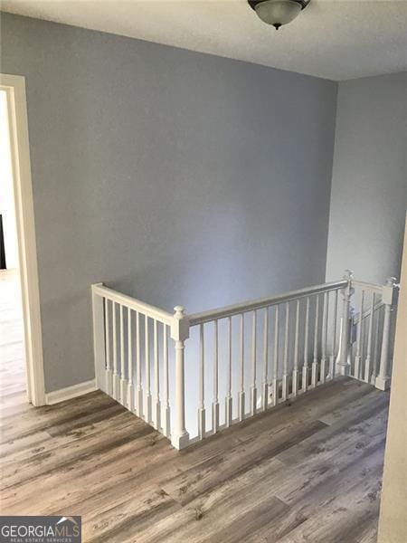 staircase with hardwood / wood-style floors