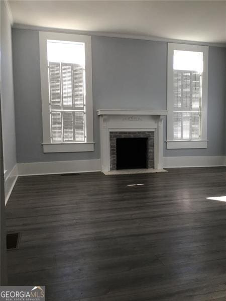 unfurnished living room with dark hardwood / wood-style floors and a healthy amount of sunlight