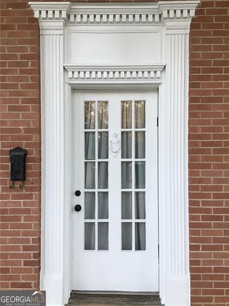 doorway to property with brick siding