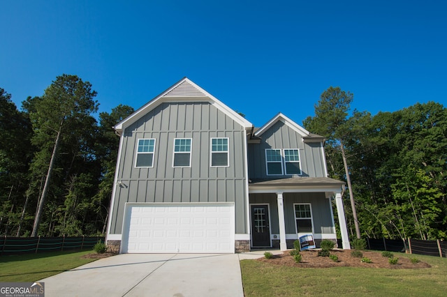 view of front facade featuring covered porch, a garage, and a front lawn