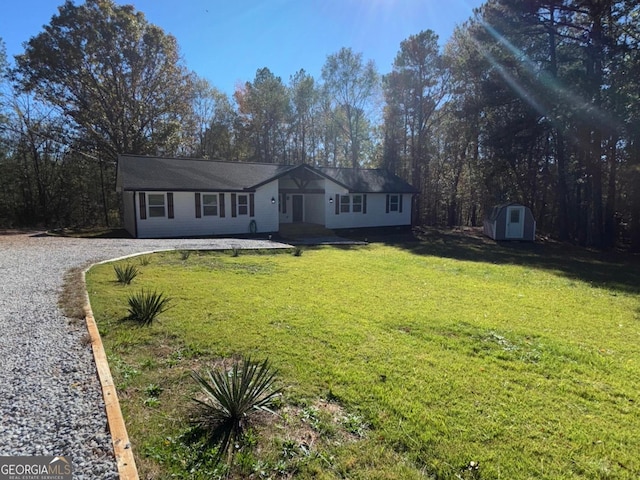 single story home with a storage shed and a front lawn