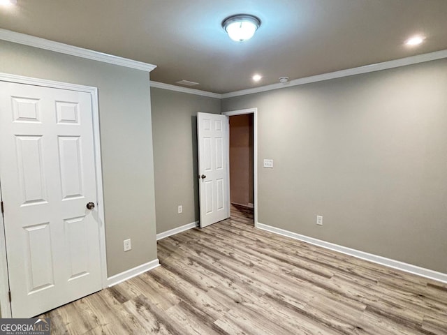 unfurnished bedroom featuring light hardwood / wood-style flooring, a closet, and ornamental molding