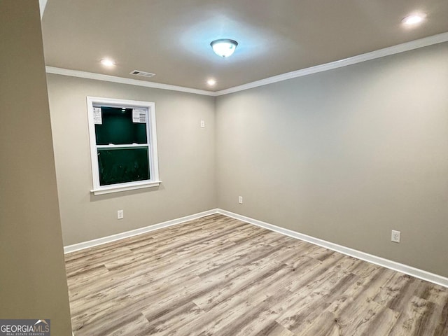 unfurnished room featuring crown molding and light hardwood / wood-style floors