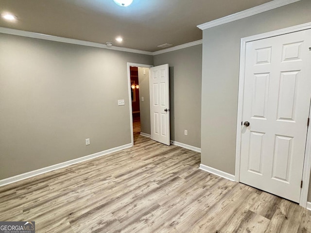 unfurnished bedroom with light wood-type flooring and ornamental molding