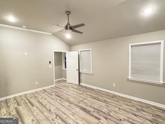 unfurnished room featuring ceiling fan, light wood-type flooring, crown molding, and vaulted ceiling