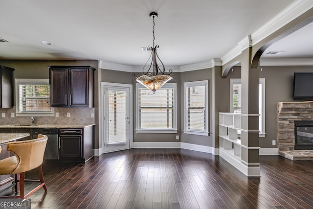 kitchen featuring dark wood-type flooring, a healthy amount of sunlight, dishwasher, and hanging light fixtures